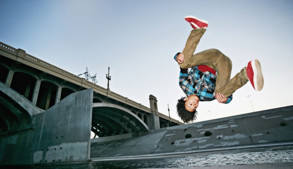 Asian man break dancing under overpass