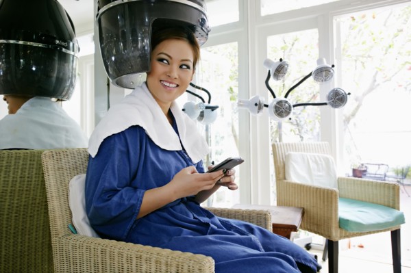 Asian woman having hair done in salon