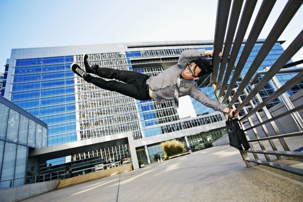Asian businessman doing tricks on handrail