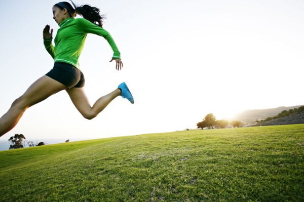 Hispanic woman running in rural landscape
