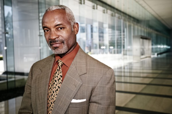 Black businessman smiling in office corridor