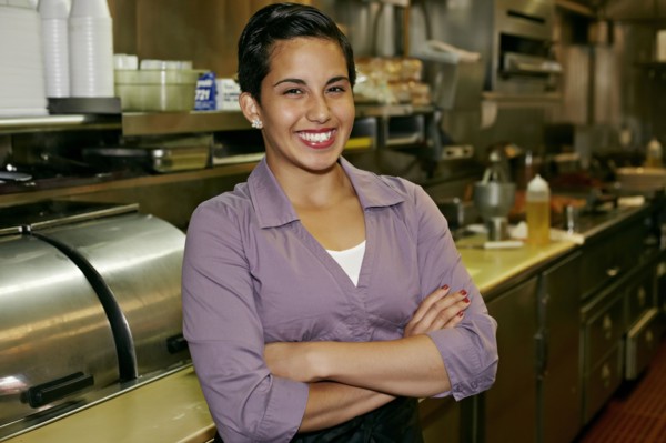 Hispanic waitress smiling in restaurant