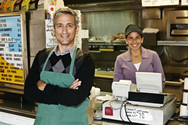 Hispanic servers smiling in restaurant