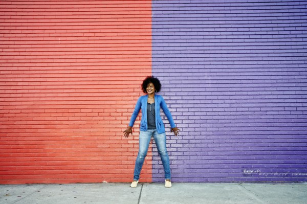 Mixed race woman standing by colorful wall