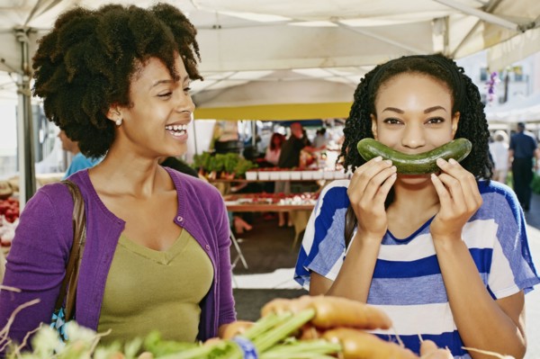 Women smiling together at outdoor market