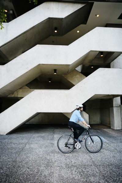 Caucasian businessman riding bicycle outside office building