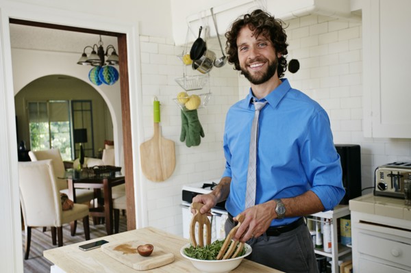Caucasian businessman cooking in kitchen