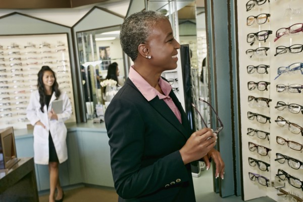 Black woman trying on glasses at optometrist