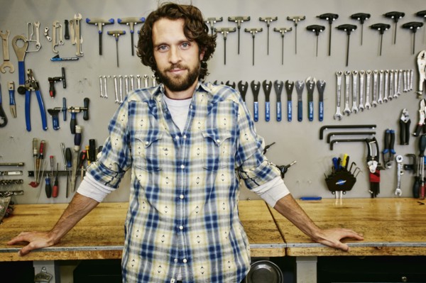 Caucasian man smiling in bicycle repair shop