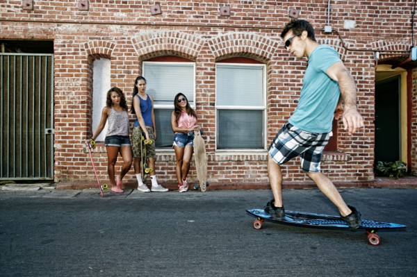 Friends riding longboards on city street