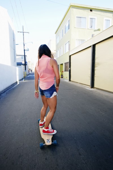 Woman riding longboard on city street