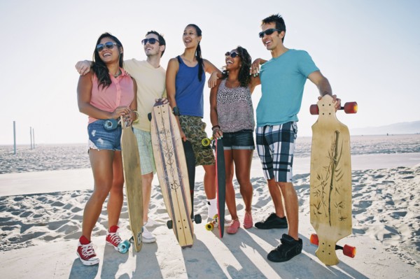 Friends holding longboards on beach