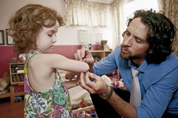 Caucasian father examining daughter's scrape