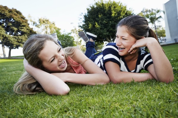 Teenage girls laying in grass