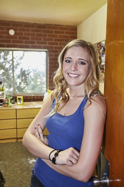 Caucasian student smiling in dorm room