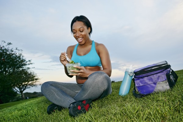 Pregnant woman eating salad in park