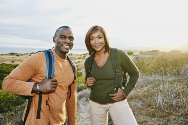 Black couple smiling on rural hillside