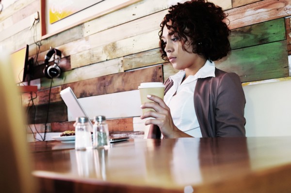 Mixed race businesswoman using laptop in cafe