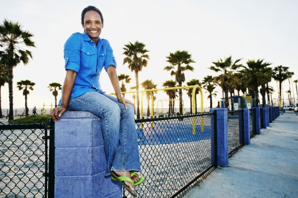 Older Black woman relaxing by park on beach