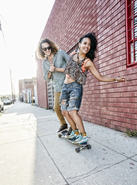 Couple riding skateboard on city street