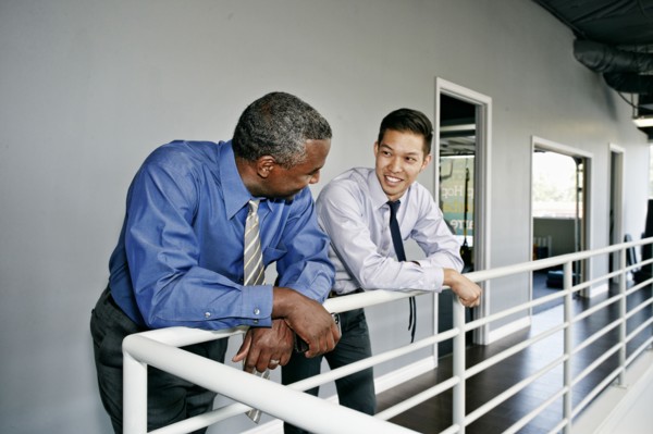 Businessmen talking at railing