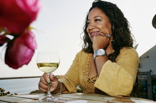 Mixed race woman drinking wine at waterfront