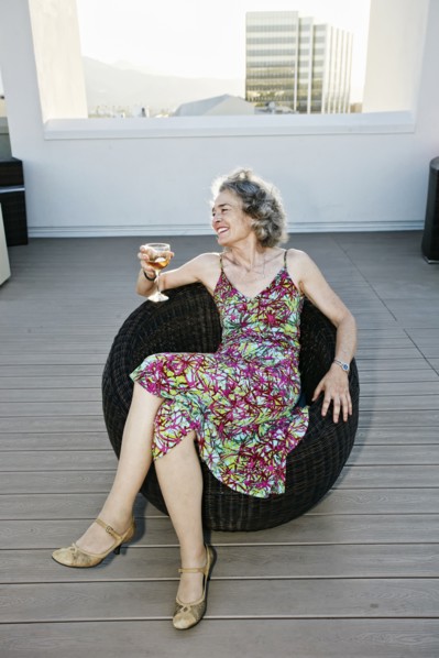 Caucasian woman drinking wine on urban rooftop