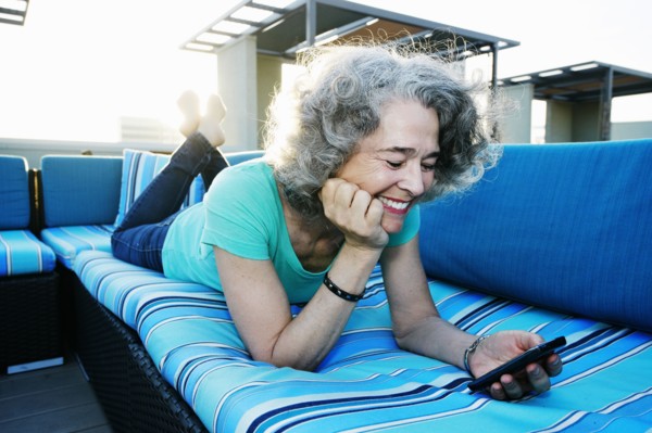 Caucasian woman using cell phone on urban rooftop
