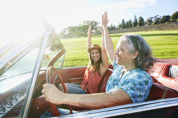 Mother and daughter driving in classic convertible
