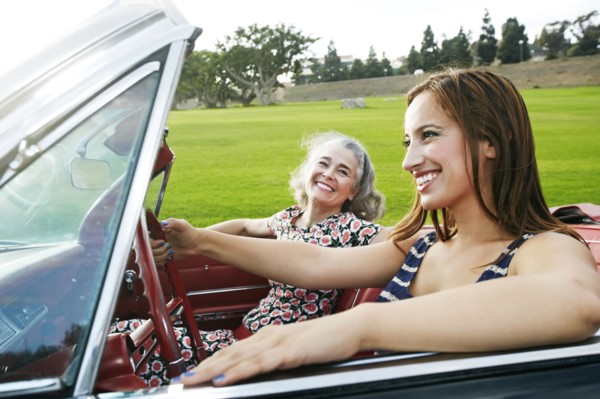 Mother and daughter driving in classic convertible