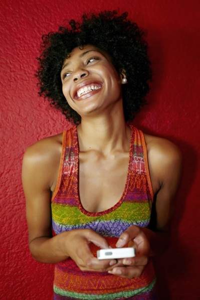 Smiling black woman using cell phone