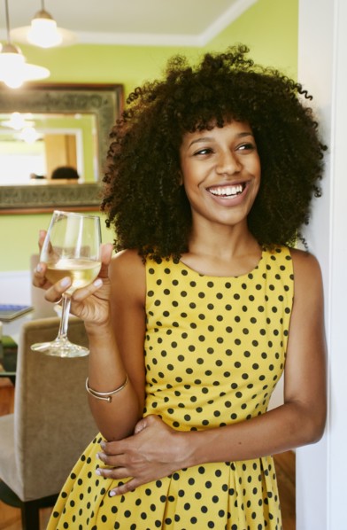 Mixed race woman drinking glass of white wine