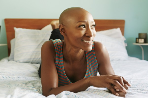 Smiling African American woman laying on bed
