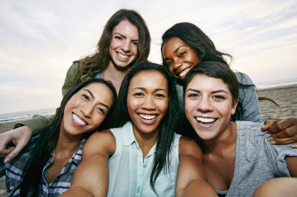 Smiling women taking selfie on beach