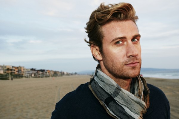 Serious Caucasian man standing on beach