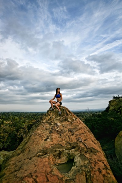 Vietnamese woman sitting on rocky hilltop