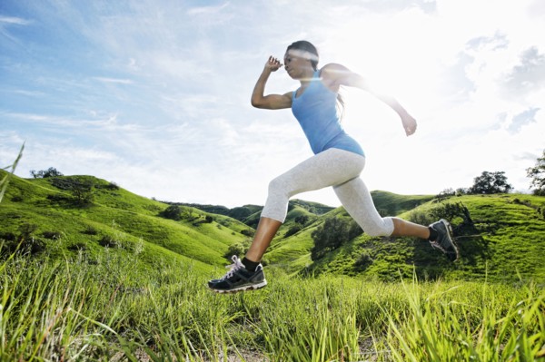 Black athlete running on rural hilltop