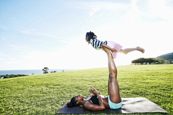Mother holding daughter with legs in park