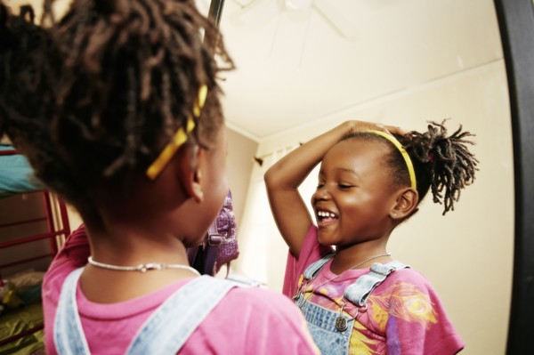 Black girl admiring herself in mirror