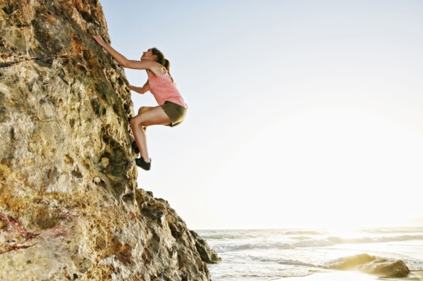 Woman climbing rock formation