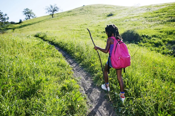 Black girl walking on rural path