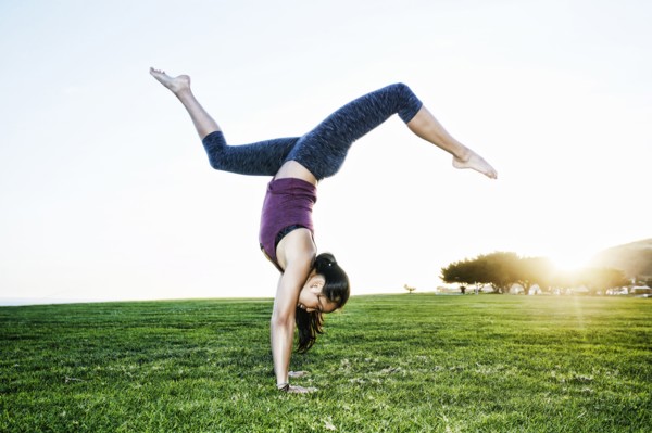 Asian woman practicing yoga outdoors
