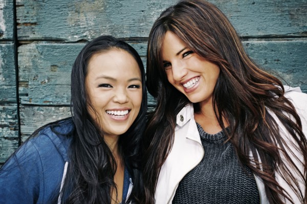 Women smiling at wooden wall