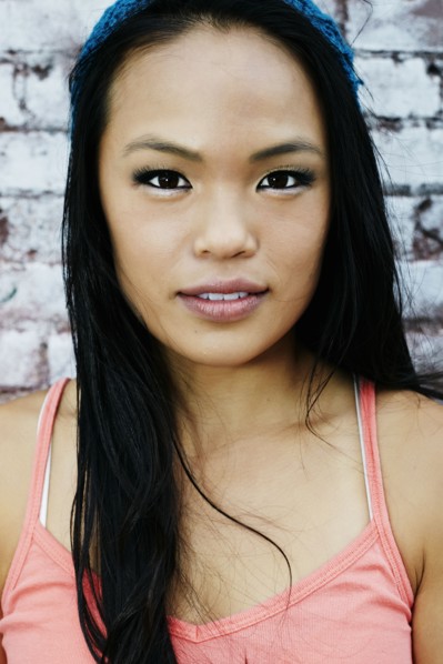 Serious Asian woman at brick wall