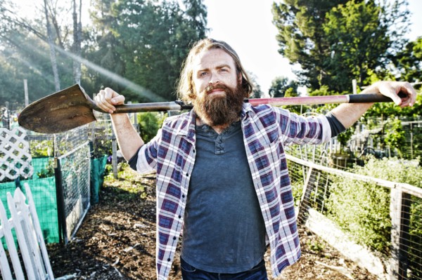 Caucasian man holding shovel in garden