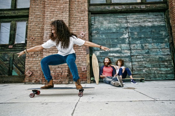 Family riding skateboards on sidewalk