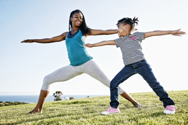 Black mother and daughter practicing yoga