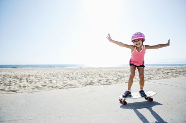 Girl riding skateboard at beach