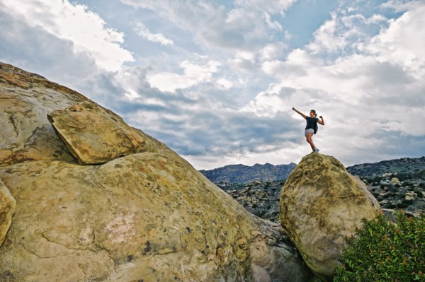 Mixed race woman climbing rock formation