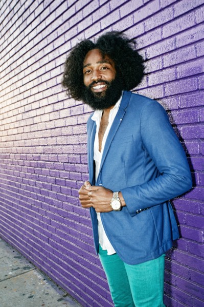 Mixed race man smiling outdoors near purple wall